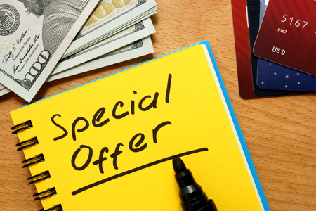 Notepad with special offer on a wooden table.の写真素材