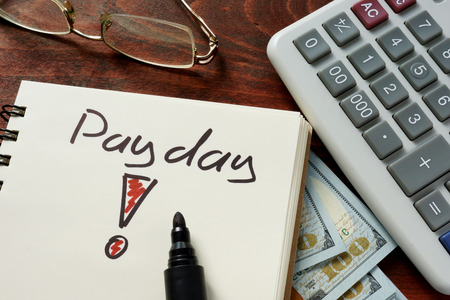 Payday written on notebook with dollars.の写真素材