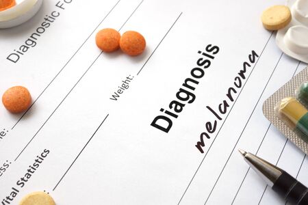 Diagnosis melanoma written in the diagnostic form and pills.の写真素材