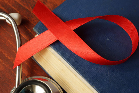HIV AIDS diagnosis.  Awareness red ribbon on a book.