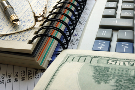 Note with data, calculator and cash. Financial accounting concept.の写真素材