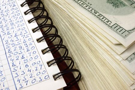 Ledger and one hundred dollar banknotes. Financial accounting concept.の写真素材