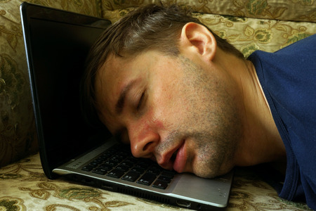 Overworked freelancer sleep on a laptop.の写真素材