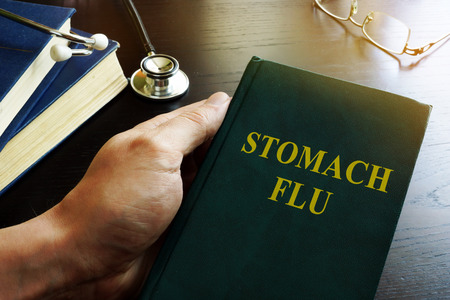 Doctor holding book about stomach flu.の写真素材