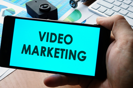 Video marketing concept. Hands are taking smartphone.の写真素材