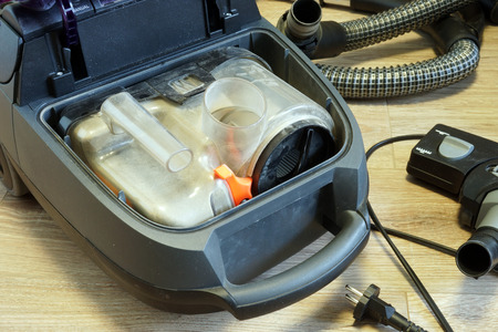 Open vacuum cleaner full of dust. Home cleaning.の写真素材