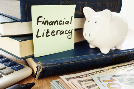 Financial Literacy written on a stick and piggy bank as savings symbol.の写真素材