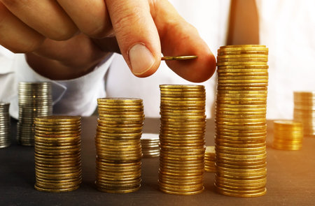 Profit growth. Man is putting coin on a stack. Wealth management.の写真素材