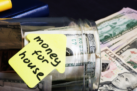 Money for house. Jar with dollars on a desk.の写真素材