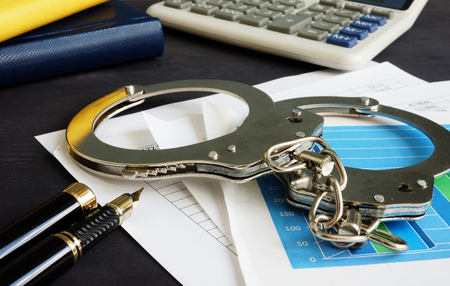 Financial fraud concept. Business documents and handcuffs.の写真素材