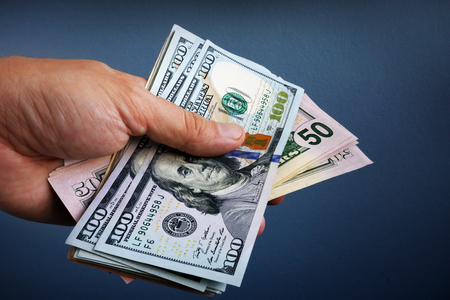 Hand is holding dollar banknotes. Loan and borrowing.