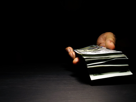 Hand offers dollar banknotes with free space. Money for lending.の写真素材
