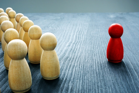 Leadership concept. Crowd of wooden figures and red one.の写真素材
