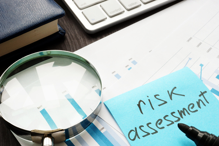 Risk assessment. Magnifying glass and documents on a table.の写真素材