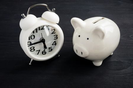 Time for savings. Piggy bank for money and watch.の写真素材