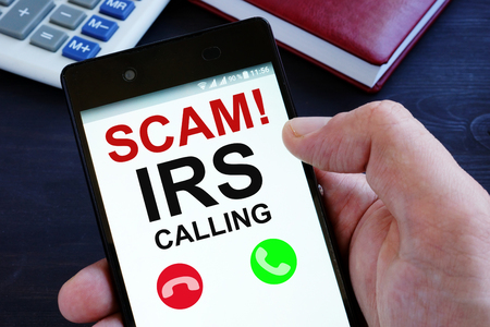 Hand is holding phone with irs scam calls.の写真素材