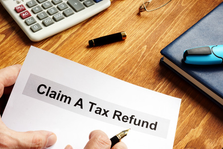 Man is holding Claim a tax refund documents.の写真素材
