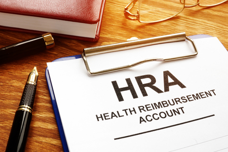 Health Reimbursement Account HRA with clipboard on desk.の写真素材