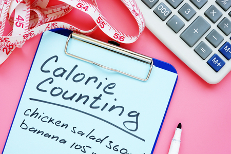 Calorie counting list for weight loss on desk.の写真素材