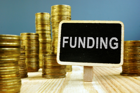 Funding concept. Coins stack on wooden surface.の写真素材