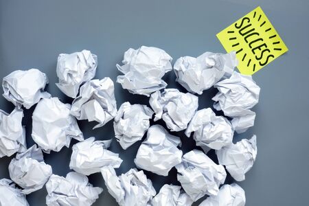 Lot of paper balls and word success as symbol of motivation and progress in business.の写真素材