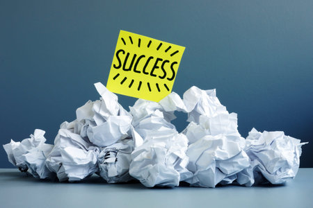 Stack of paper balls as symbol of failure and word success on top.