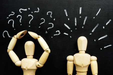 Wooden figurines question and exclamation marks as symbols of difficulties in communication.