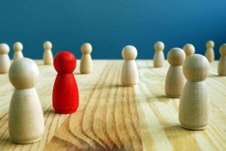 Inclusion social concept. Red figurine between wooden figurines.の写真素材