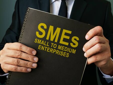 Businessman holds SMEs Small to Medium Enterprises.の写真素材