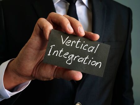 Vertical integration management concept. Man holds memo stick.の写真素材