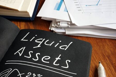 Liquid Assets list and calculations in the black notepad.の写真素材