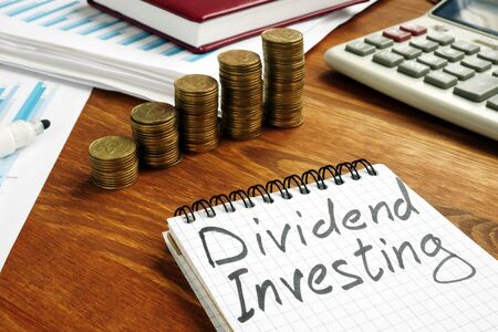 Dividend Investing sign and stacks of money.の写真素材