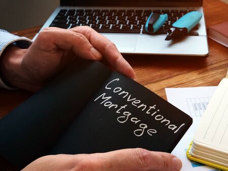 Conventional mortgage written in the black notebook.の写真素材