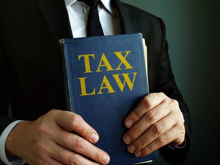 Accountant holds tax law book.の写真素材