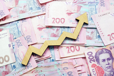 Rising arrow and Ukrainian hryvnia. Economic growth and money exchange.