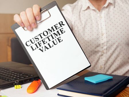 Man is holding Customer lifetime value report.の写真素材