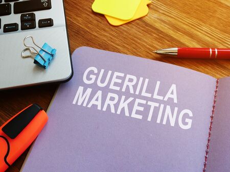 Guerilla marketing guide and laptop on the desk.の写真素材