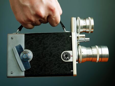 Hand holds retro film camera. Video content marketing and blogging concept.の写真素材
