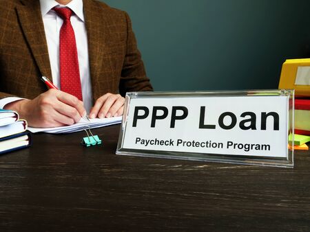 PPP loan and Paycheck Protection Program title on the plate in the office.の写真素材