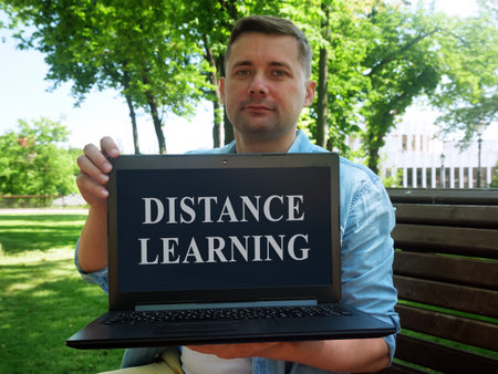 Distance learning concept. Student shows a laptop with the inscription.