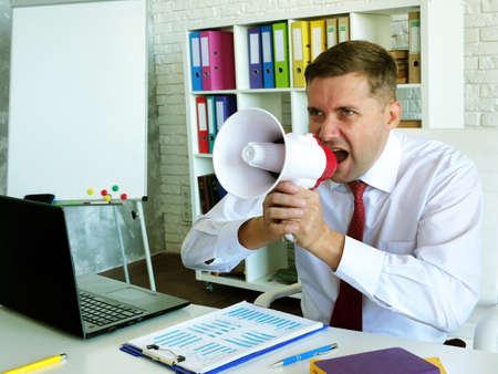 Thought and charismatic leadership. Boss with loudspeaker in the office.の写真素材