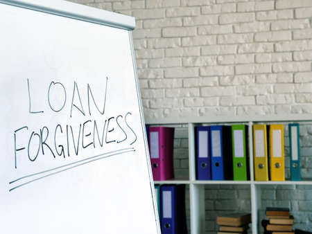Loan forgiveness inscription on the white board in the office.の写真素材
