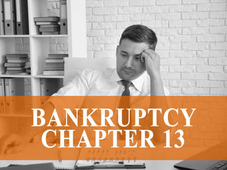 Bankruptcy chapter 13 concept. A pensive businessman is sitting at the table.の写真素材