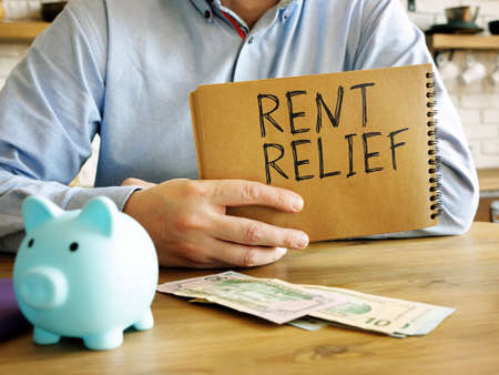 Rent relief. A man at home holds a handwritten lettering.の写真素材