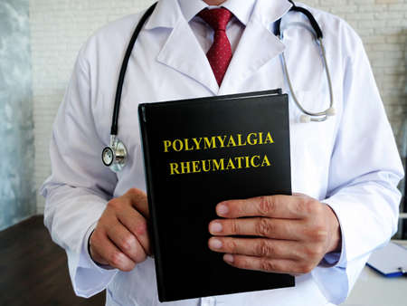 The doctor is holding a book about the polymyalgia rheumatica disease.の写真素材