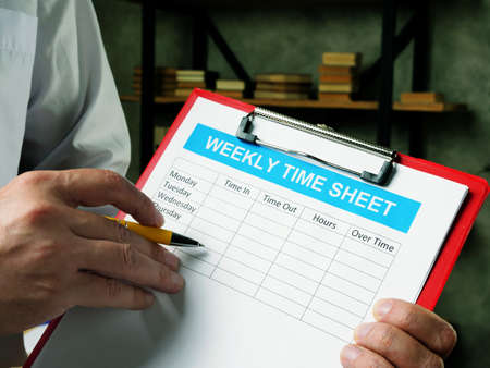 The manager fills out the weekly time sheet for employees.の写真素材