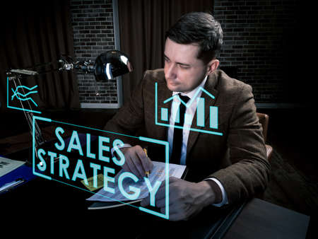 Sales strategy info concept. Man works late at the table.の写真素材