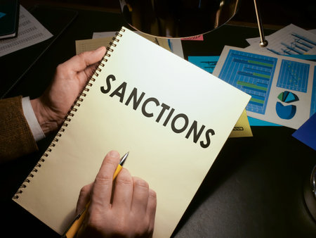 Hands hold a list of economic sanctions.