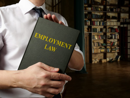 Worker holds employment law in the library.