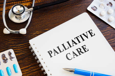 Palliative care book, pills and stethoscope on the surface.の写真素材